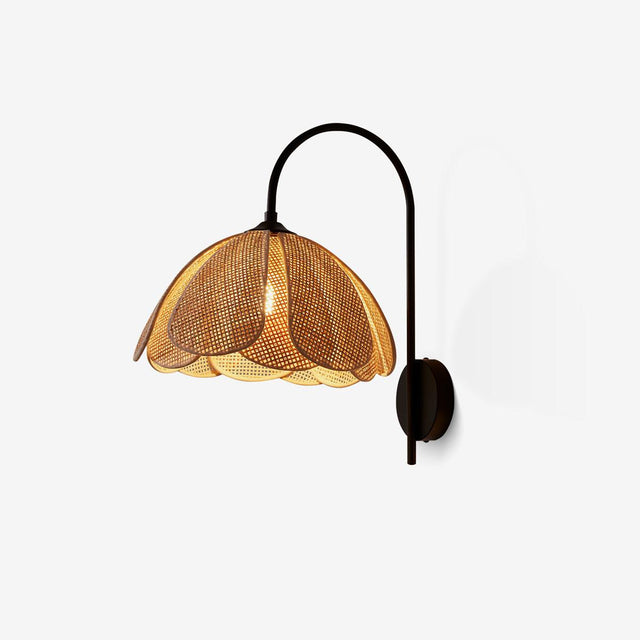Wall sconce with a black gooseneck arm and a woven rattan shade shaped like petals