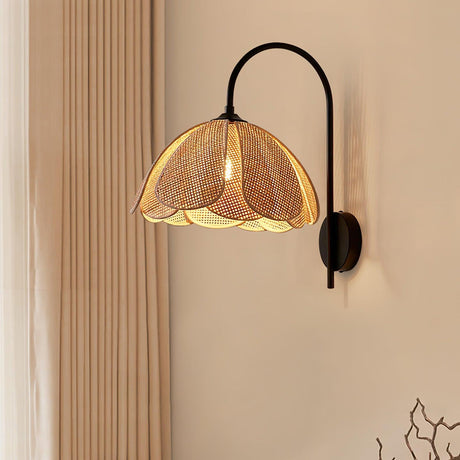 The rattan sconce lit on a beige wall beside a sheer curtain