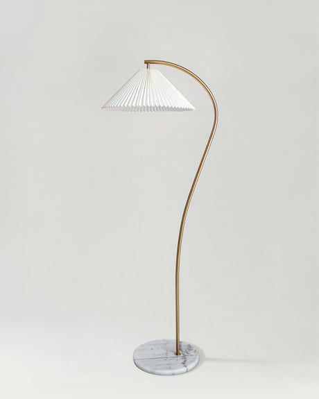 Brass floor lamp with a curved stem and a white pleated shade on a marble base