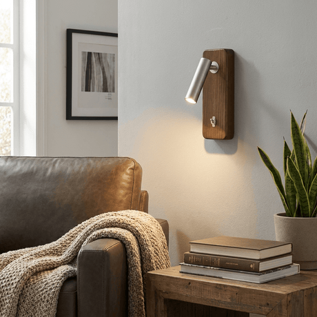 Reading sconce lit above a leather armchair and a stack of books