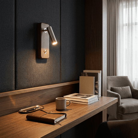 Reading sconce lit on a dark paneled wall above a wood desk