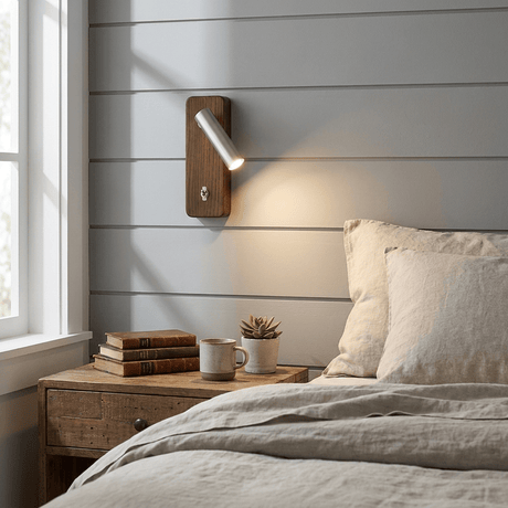 Reading sconce lit on a painted shiplap wall above a bedside table