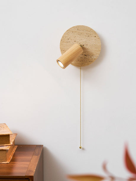 Oak head lit above a walnut nightstand stacked with a pile of books