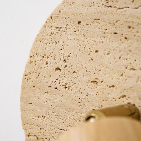 Close view of the pitted travertine surface across the face of the disc