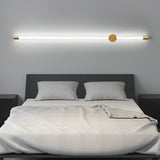 Mounted horizontally above a made bed with white pillows and a gray headboard
