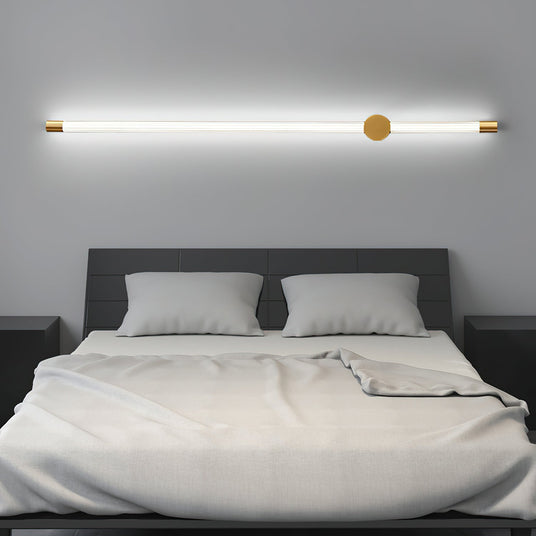 Mounted horizontally above a made bed with white pillows and a gray headboard