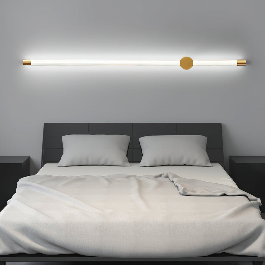 Mounted horizontally above a made bed with white pillows and a gray headboard