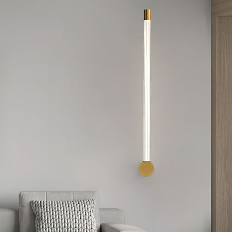 Lit beside a bed on a pale wall next to a timber panel and a knitted cushion