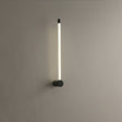 The black version lit on a gray wall, the tube glowing along its full height
