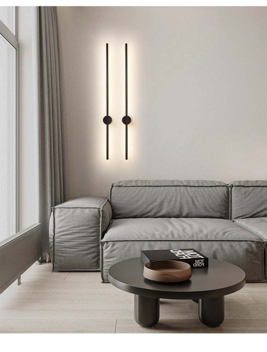 A black pair lit above a sofa and a round coffee table with a tray on it