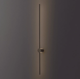The black rod lit against a dark wall, the puck foot holding it clear