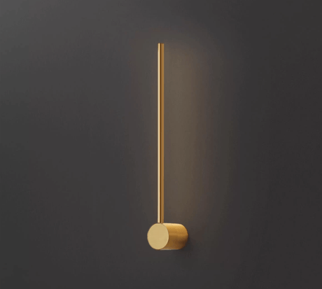 The copper puck foot seen close, the brushed metal lit from the rod above