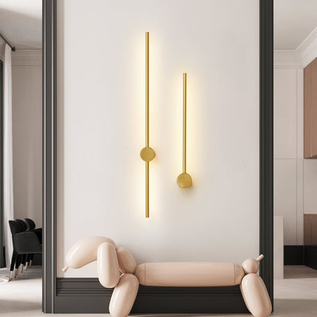 A gold pair lit above a curved bench beside a tall mirror and a dark wall
