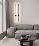 A lit pair on a pale wall above a low sofa and a round wood coffee table