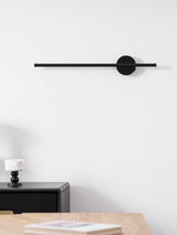 Switched off above a desk with books and a candlestick on the surface below