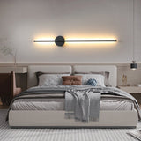 Lit horizontally above a bed with a padded headboard and folded throw