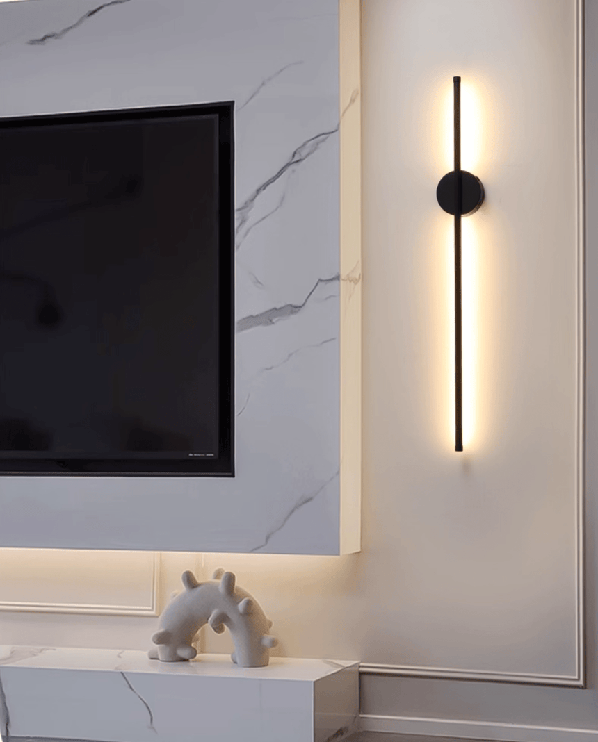 Lit vertically on a marble wall beside a television and a low display shelf