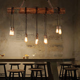 Lit over a run of stools and a counter against a concrete wall with lettering