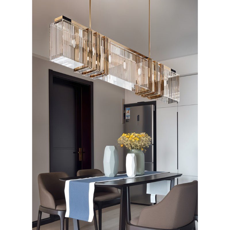 The bar lit above a dark dining table with chairs, a runner and two vases