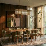 The long version above a dining table with green chairs, artwork and a window