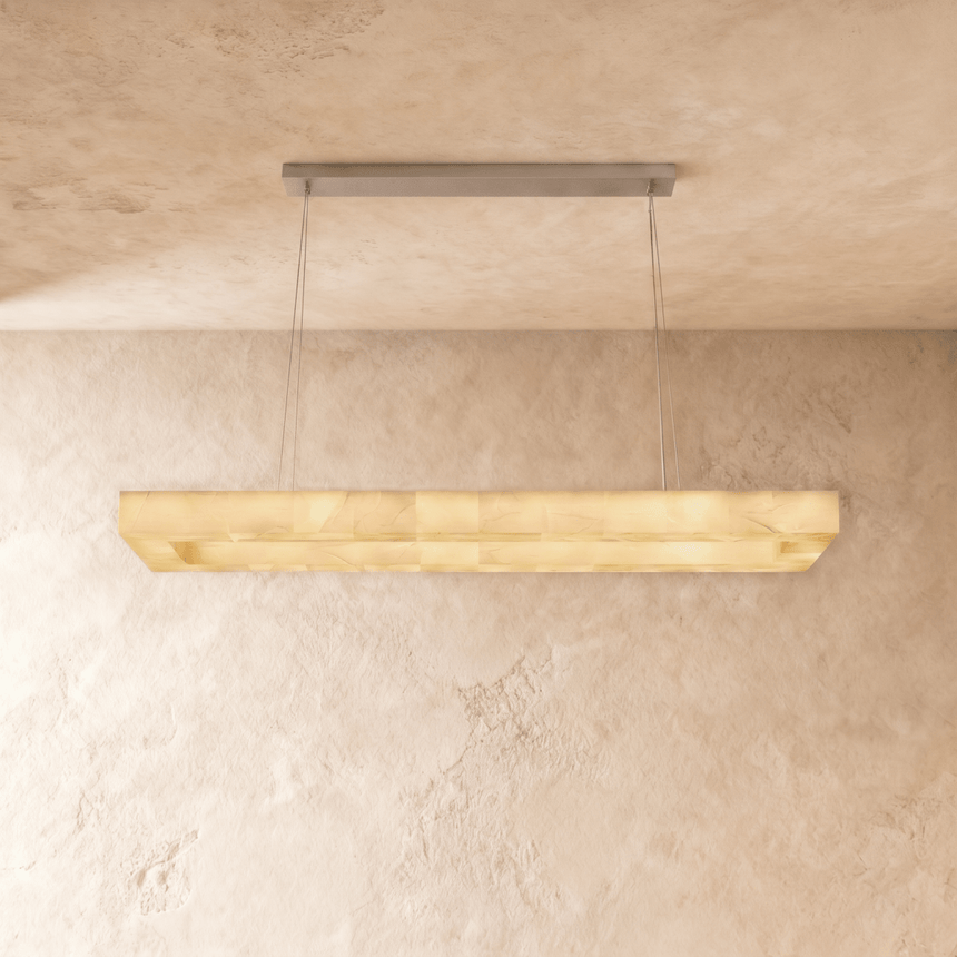 A lit alabaster bar seen from below against a plaster ceiling