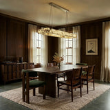 A lit bar above a dining table in a dark paneled dining room