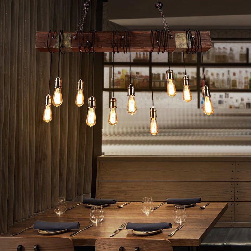 Lit above a set table with glasses and plates against vertical timber paneling