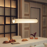 The flat lit bar hung above a long dining table with dark chairs
