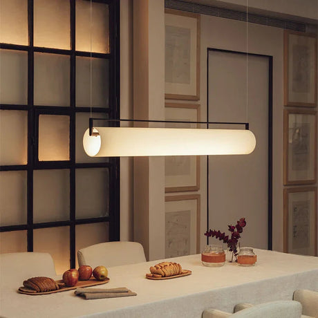 The flat lit bar hung above a long dining table with dark chairs