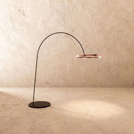 The curved black arm with a rose gold ring lit at the end above a disc base