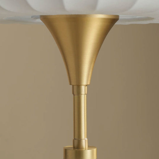 Close view of the brass trumpet where the stem meets the shade