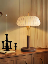 Remote control table lamp lit on a cabinet beside a candelabra