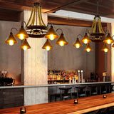 Two of the chandeliers lit above a long bar counter and stools