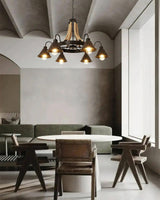 The horns lit above a dining table in a plain plaster room