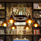 The fitting lit in a room lined with bookshelves and a wood table