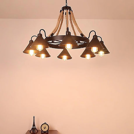 The chandelier lit warm in a room with a soft pink wall behind
