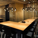 The fitting lit above a long wood table in a slatted wall room
