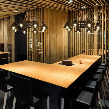 The fitting lit above a long wood table in a slatted wall room