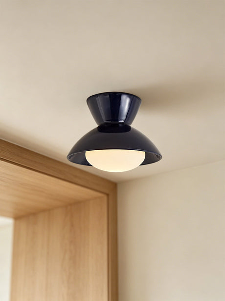 Black gourd ceiling light mounted beside a wood door frame