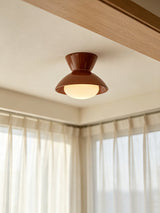 Terracotta red gourd ceiling light near a curtained window