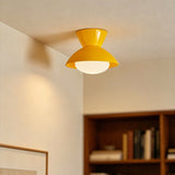 Yellow gourd ceiling light on a sloped ceiling above a bookshelf