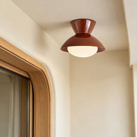 Terracotta red gourd ceiling light beside a rounded window reveal