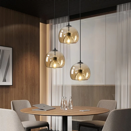 A row of amber and smoke domes above a wooden dining table and chairs
