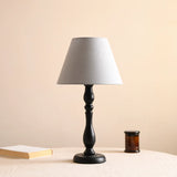 Table lamp with a muted blue shade on a turned black base, unlit