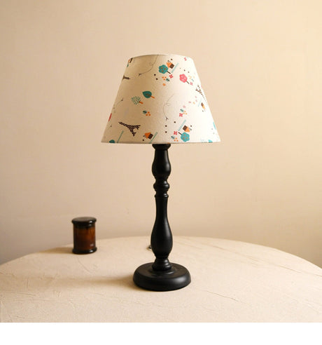 Table lamp with an off white shade printed with small doodles