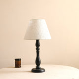 Table lamp with an off white shade finished with a lace edge trim