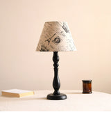 Table lamp with a printed newspaper pattern shade on a black base