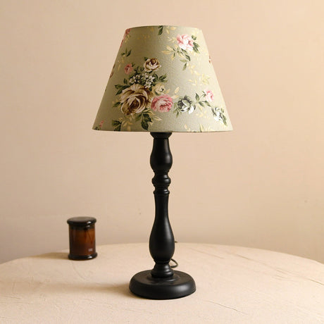 Table lamp with a pea green shade printed with roses on a black base