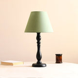 Table lamp with a solid teal green shade on a turned black base