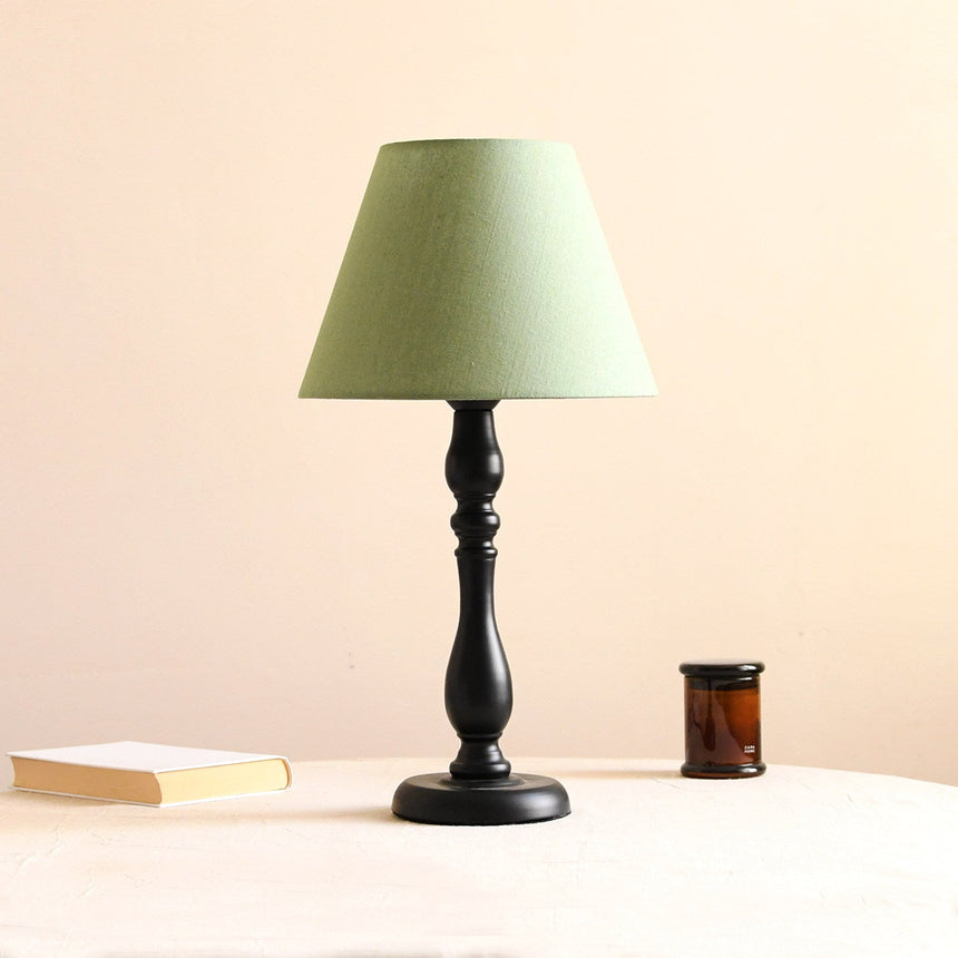 Table lamp with a solid teal green shade on a turned black base